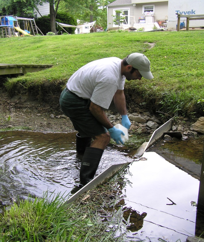 BES LTER scientist sampling water at a long-term suburban watershed site in Baltimore County, MD.