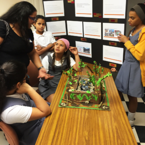 Middle school students gathered around a science project