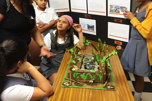 Middle school students gathered around a science project