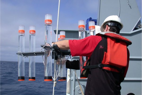 graduate student examining water collectors aboard ship