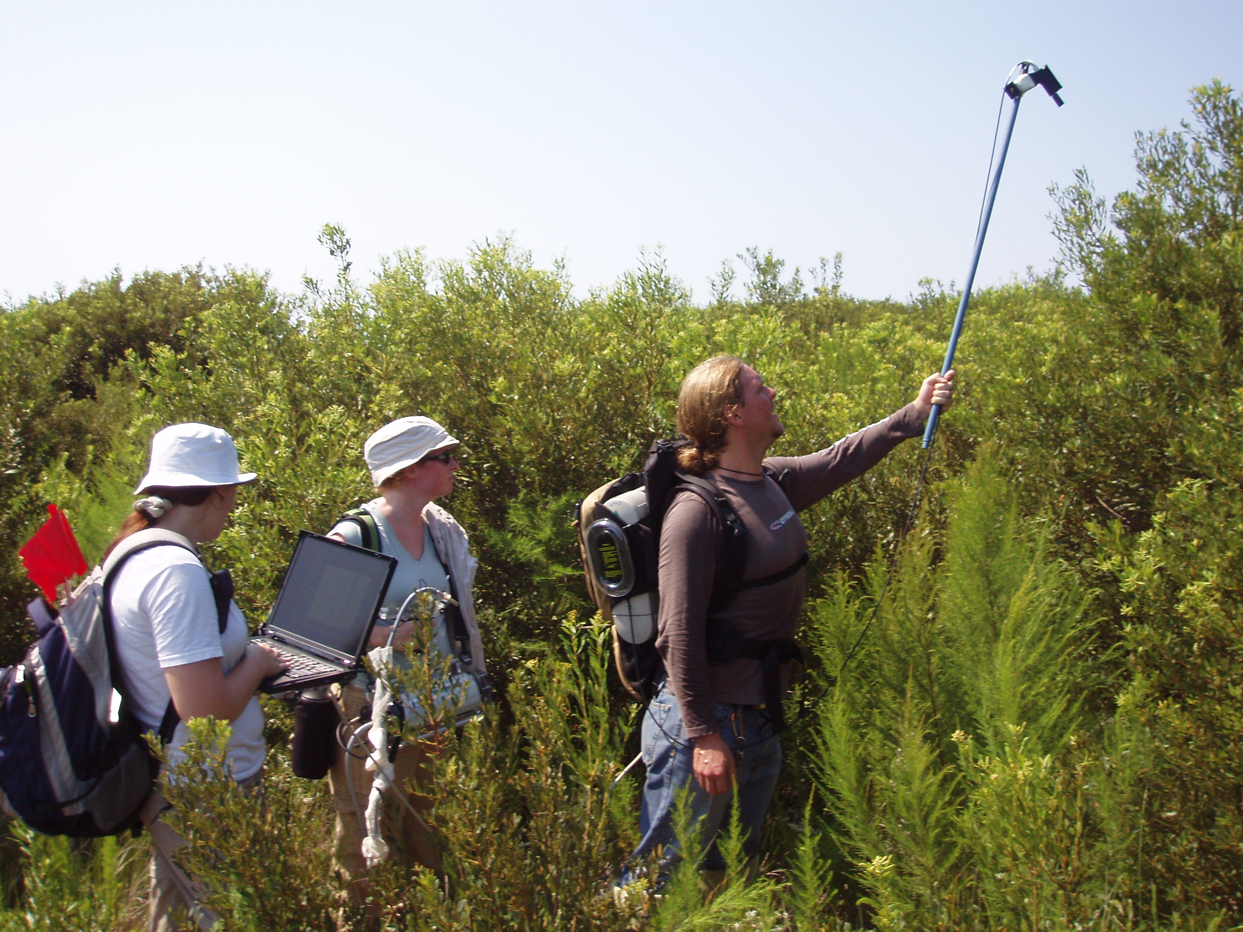 group of three students holding spectrometer aloft