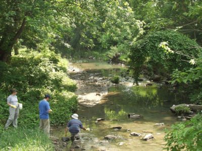 researchers and community members sampling an urban stream