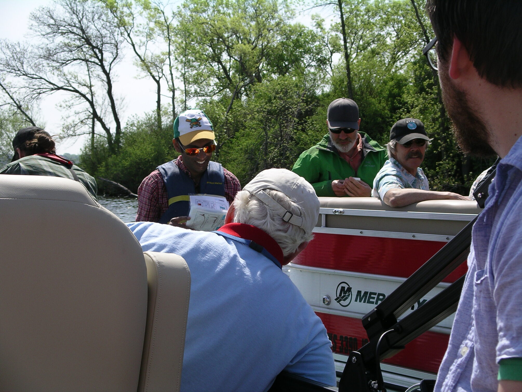 small group watching a demonstration on two boats