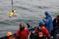 An oceanographic glider being deployed into the sea from the ship