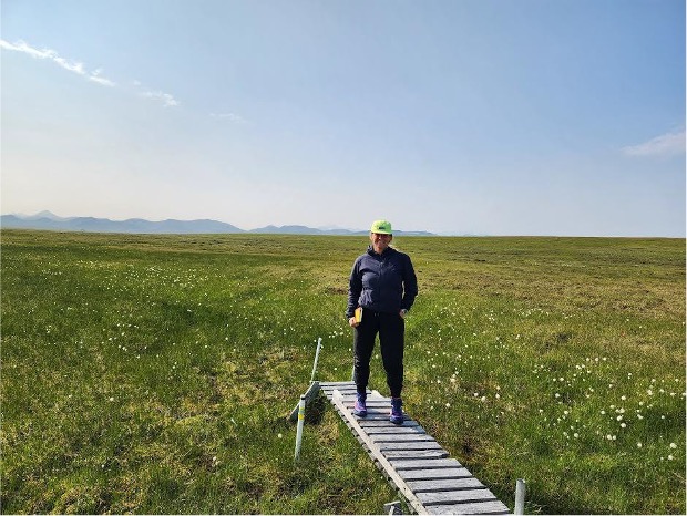 individual standing at the end of boardwalk, clipboard in-hand