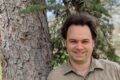 Cameron Clay, leaning against a tree