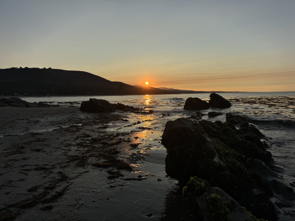 sun rising over a rocky coast