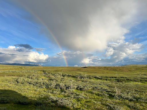 clouds and rainbow over sprawling tundra